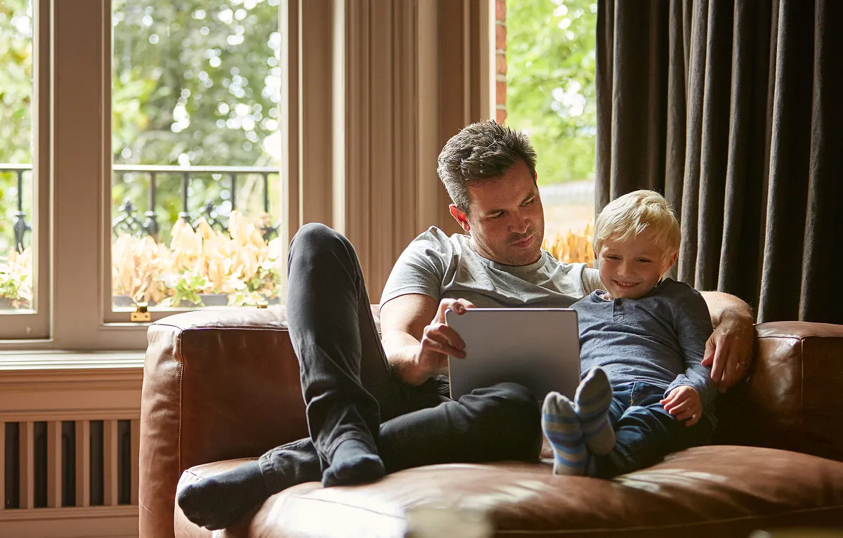 Family using a tablet on a couch